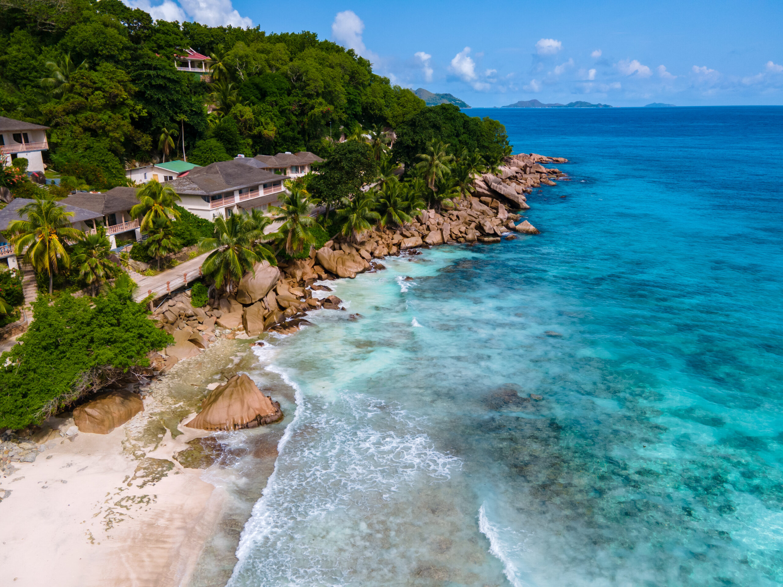 Anse Patates beach, La Digue Island, Seychelles, white beach with blue ocean and palm trees.
