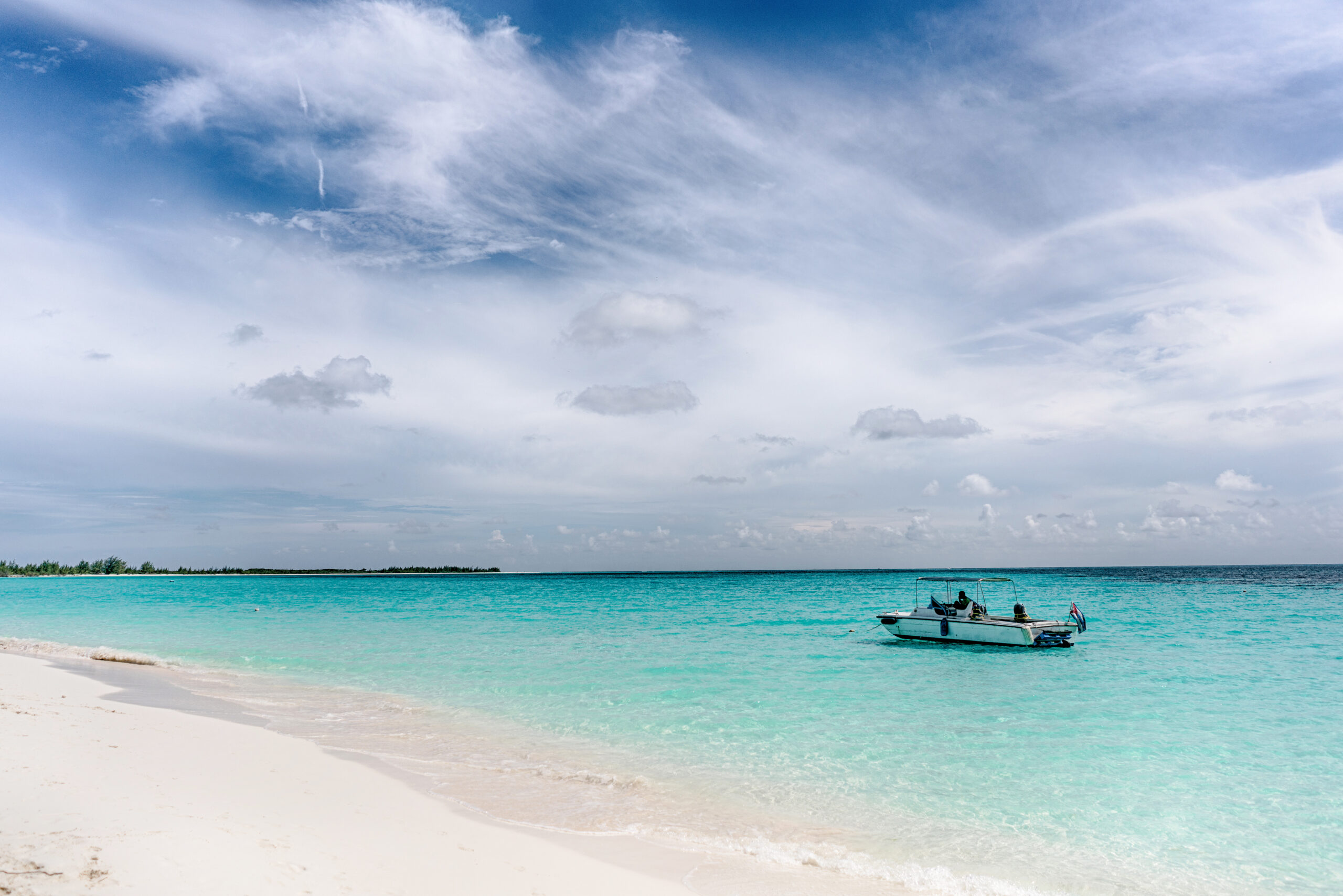 The boat in the waters of the Caribbean Sea and the view of the beach of Cayo Largo, Cuba out of the water