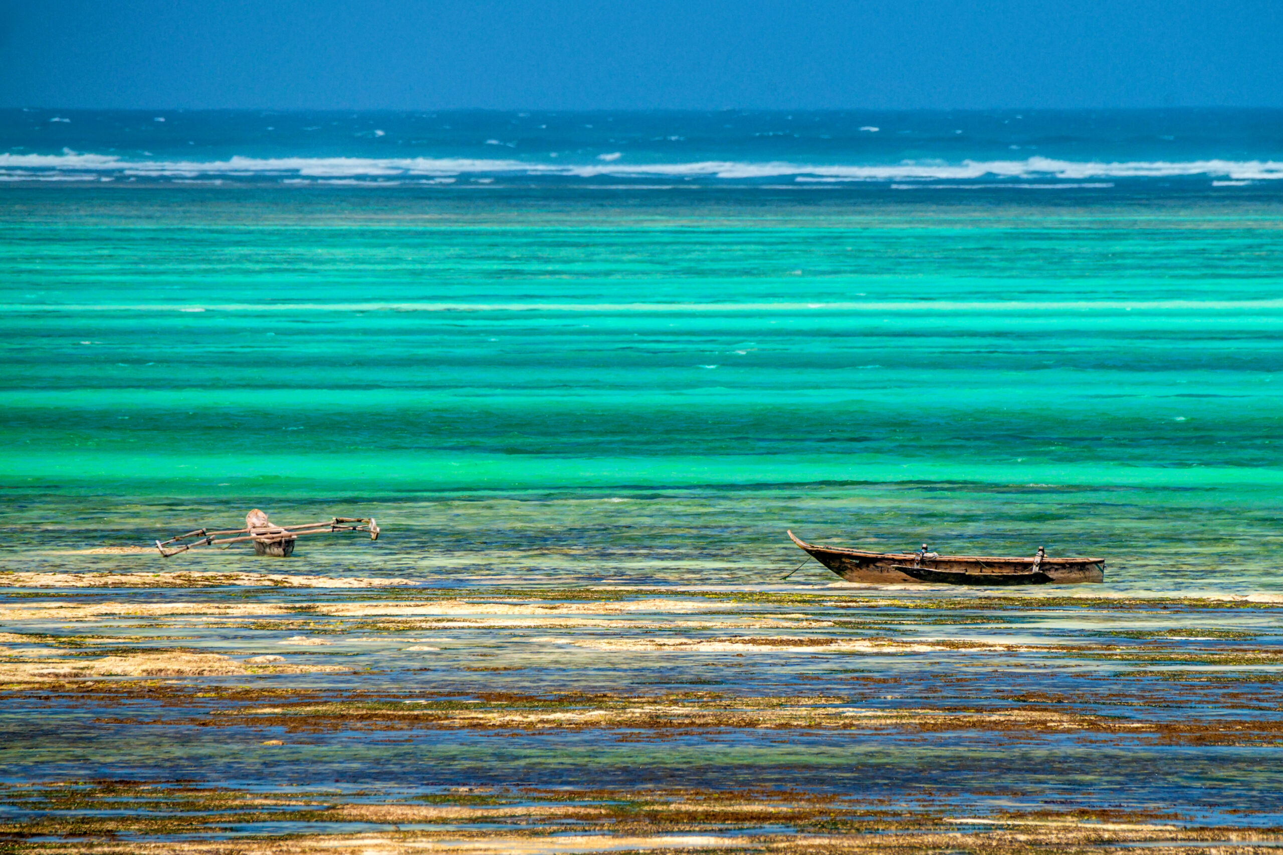 Beautiful landscape of Zanzibar littoral coastline during low tide and wooden boats on water